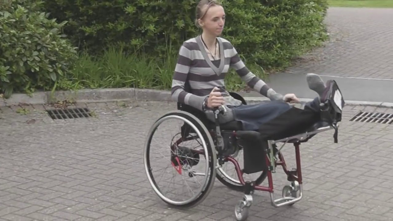 Pretty British woman crippled by an accident changing wheelchairs.