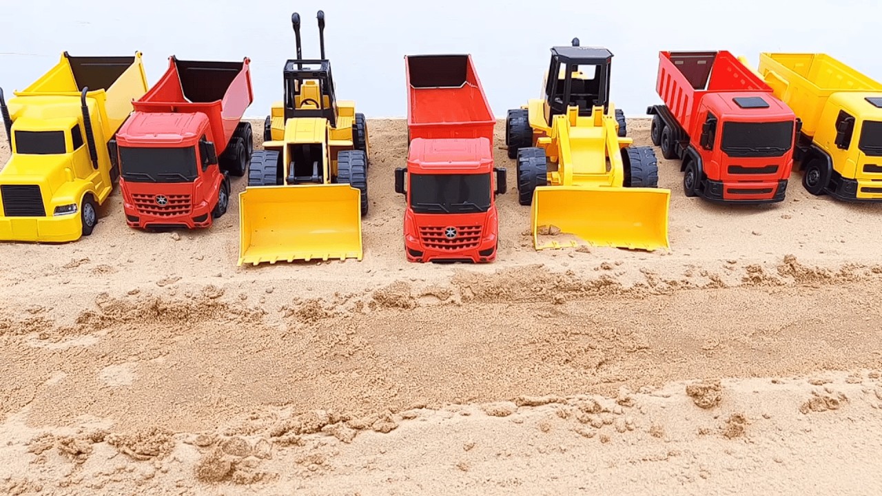Caminhão caçamba e tratores trabalhando construindo estrada na areia