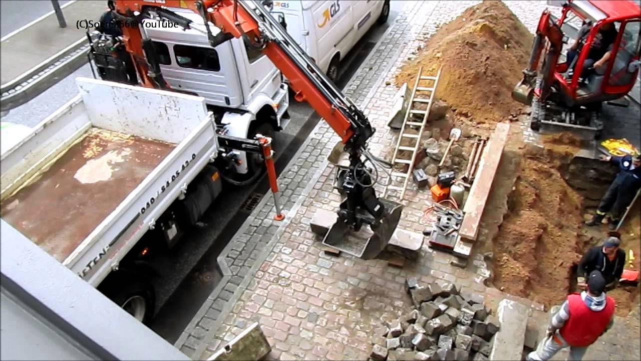 Multikpper mit Ladekran ATLAS 116 3 hebt einen Bordstein