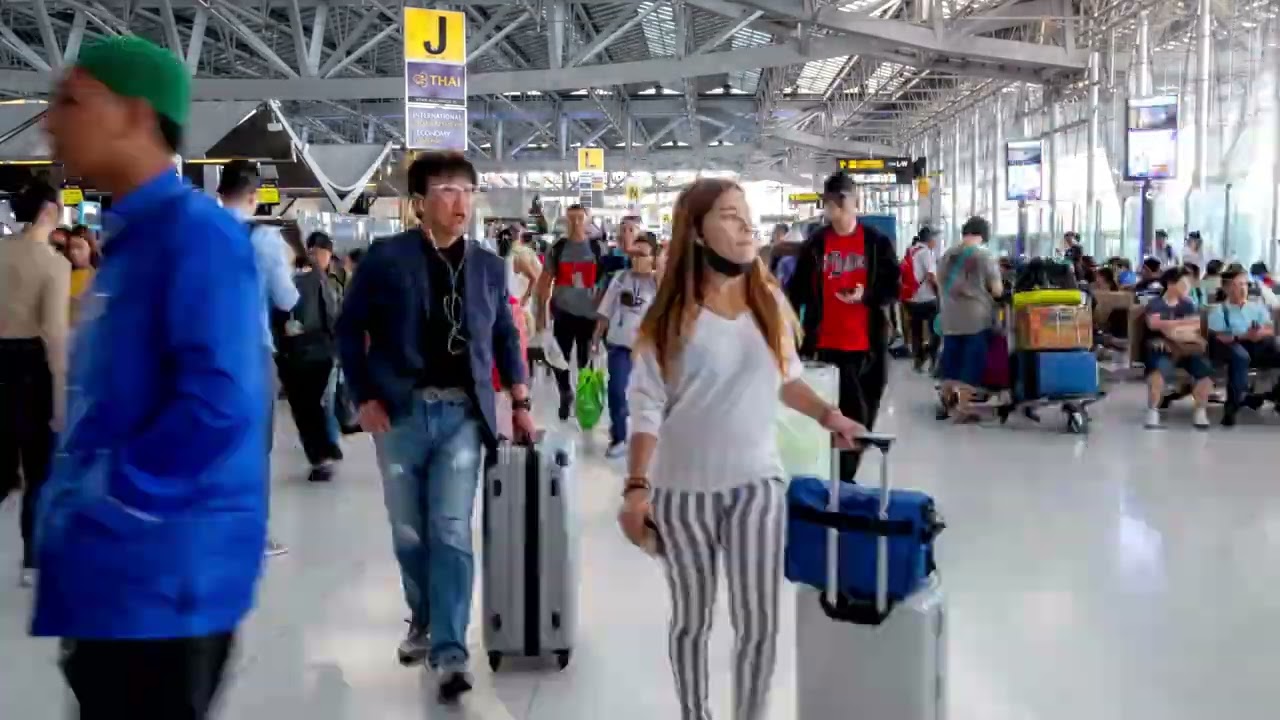VideoVault Stock Video: Large crowds of people walking through an airport timelapse