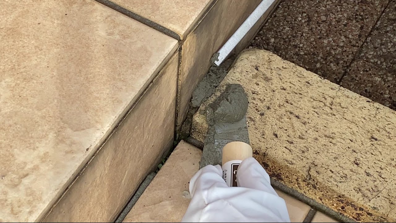 モルタルが何か知らない男がレンガの目地補修をする