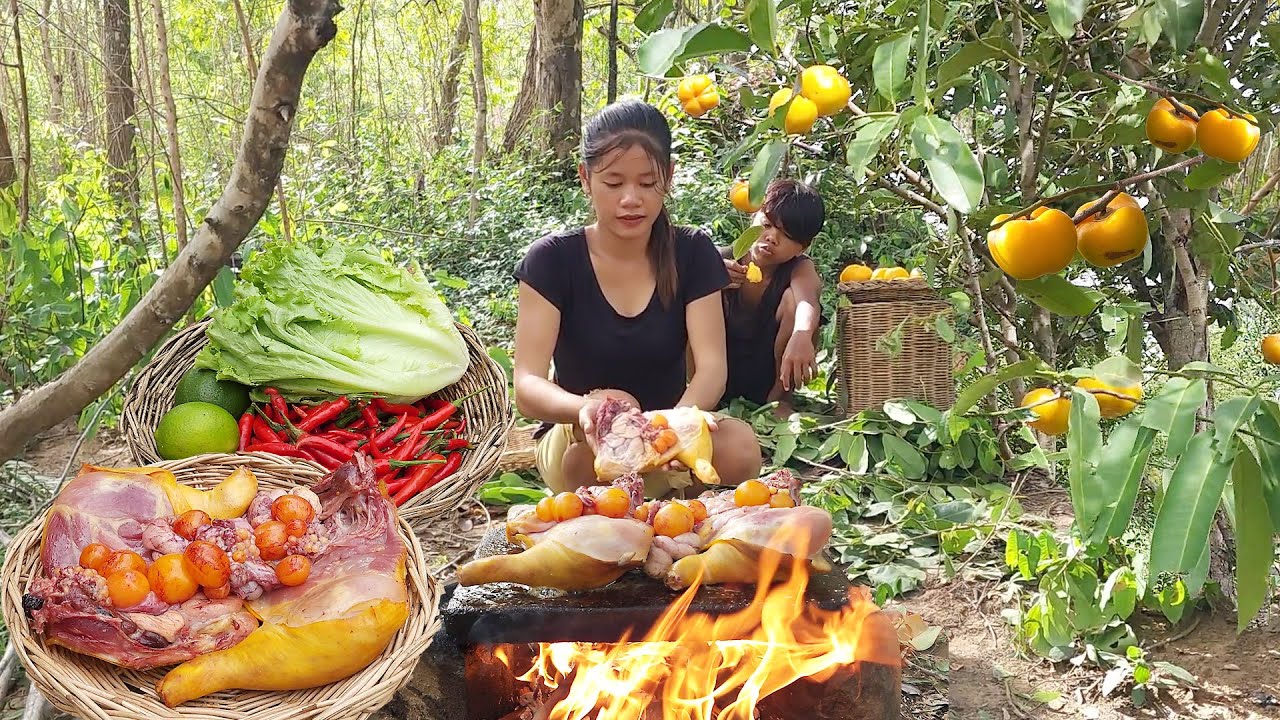 Chicken thigh and egg Cooking on rock with salad, Wild Persimmon fruit for food in jungle
