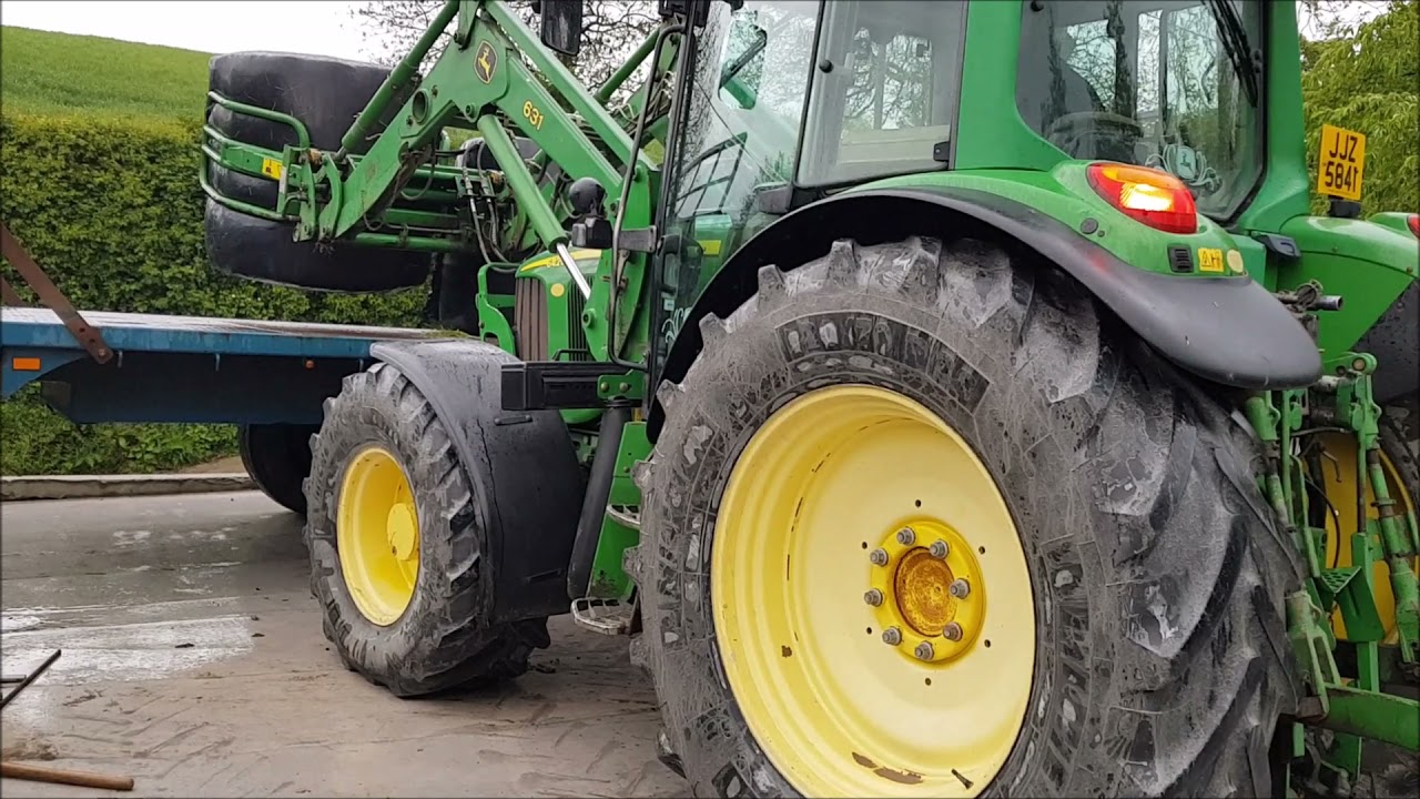stacking round bales with John Deere tractor