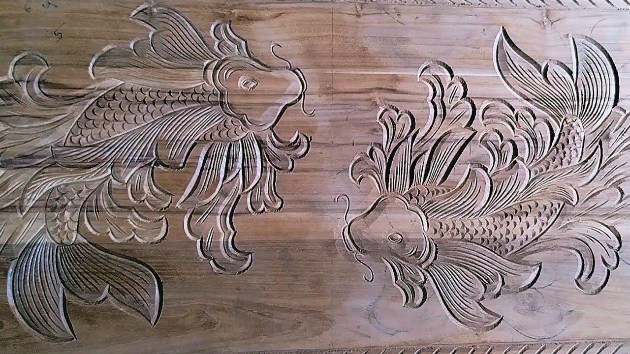wood carving koi fish motifs on wooden boards using manual carving tools