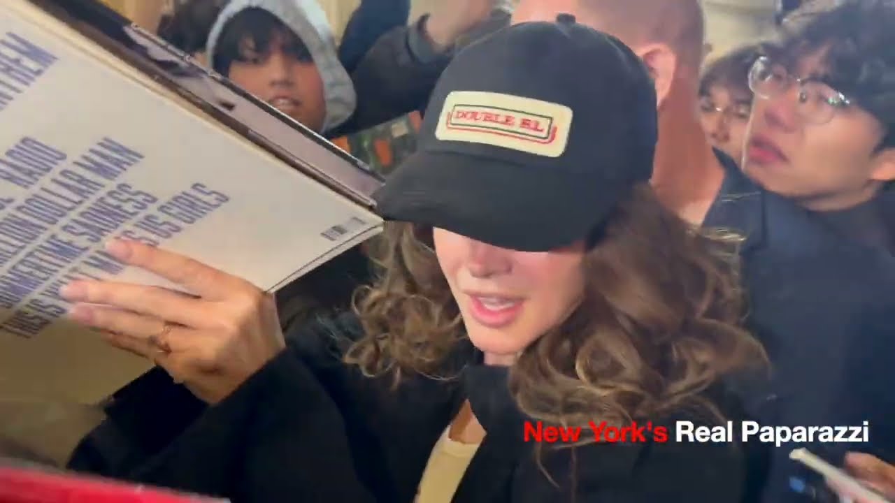 Lana Del Rey walks through a big crowd of fans in New York.