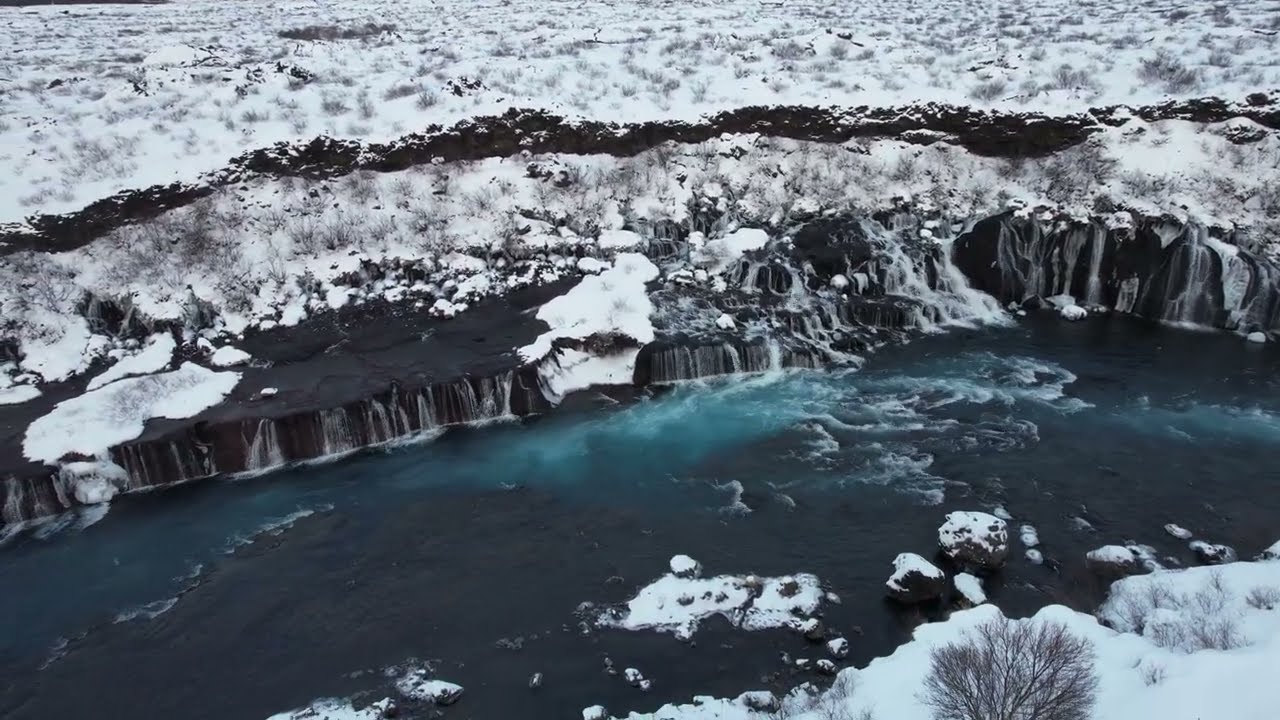 Hraunfossar Falls (Lava falls) and Hallmundarhraun lavafield. Iceland. 4K Drone.
