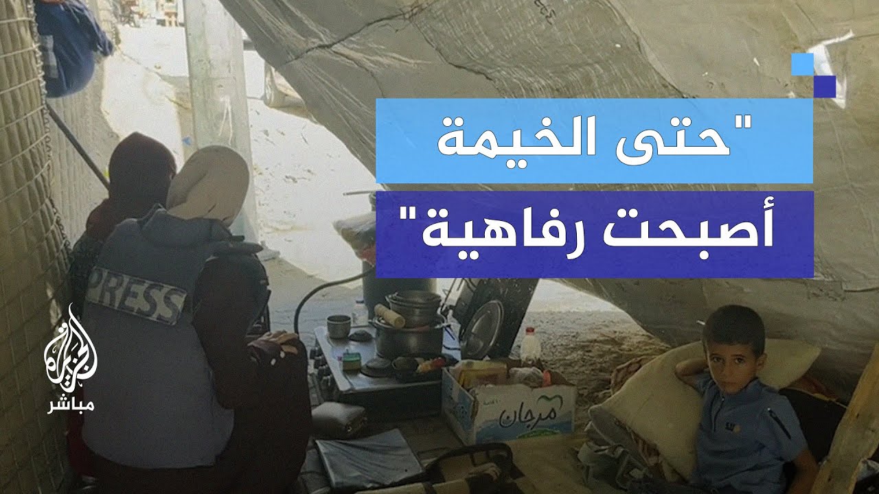 عائلة فلسطينية نازحة تسكن تحت قطع من القماش على الطريق في خان يونس