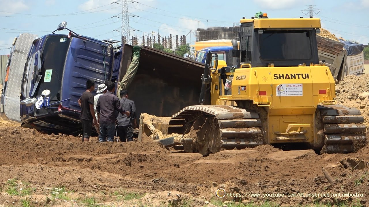 A Big Dozer push the dirt And Dump Truck unloading dirt