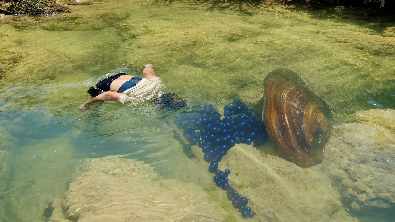 There is an invincible giant clam spitting out charming blue pearls and playing in the river water