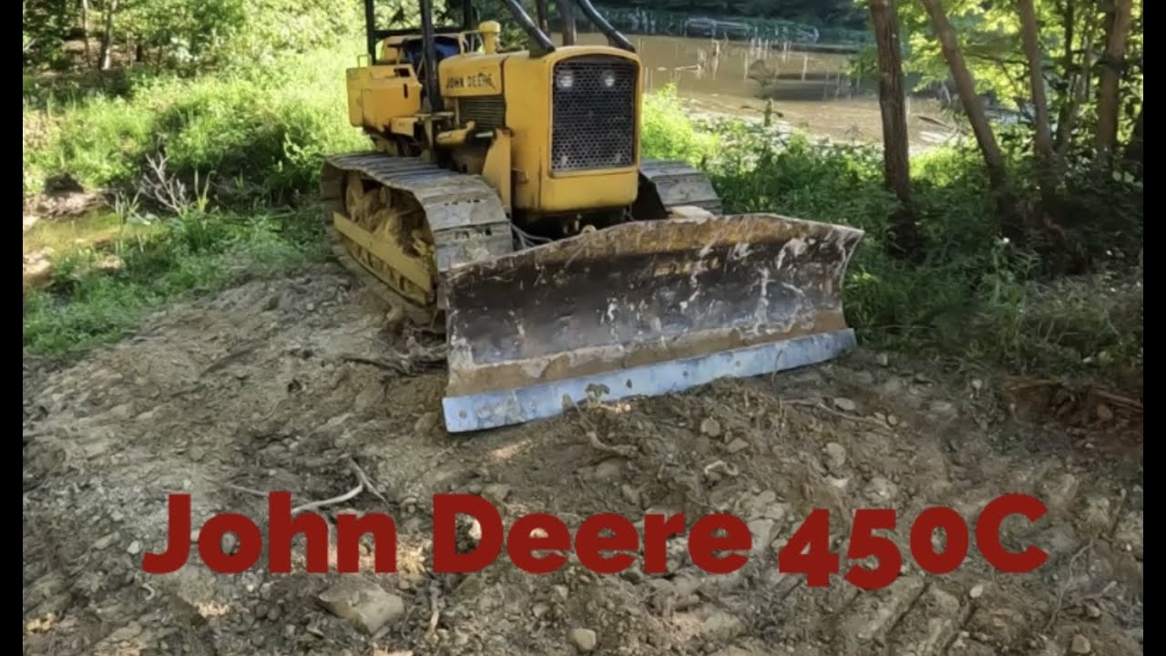 John Deere 450c pushes hard clay and concrete slab