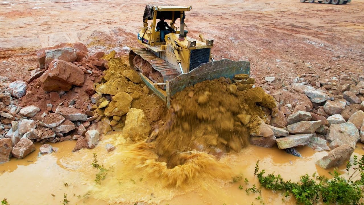 Perfectly Land Reclamation Process With Strong Bulldozer Work Moving Big Stones in Lowland Area