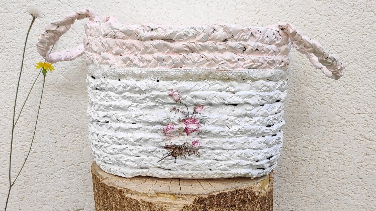Cesta de falso mimbre con garrafa de agua y papel de periódico