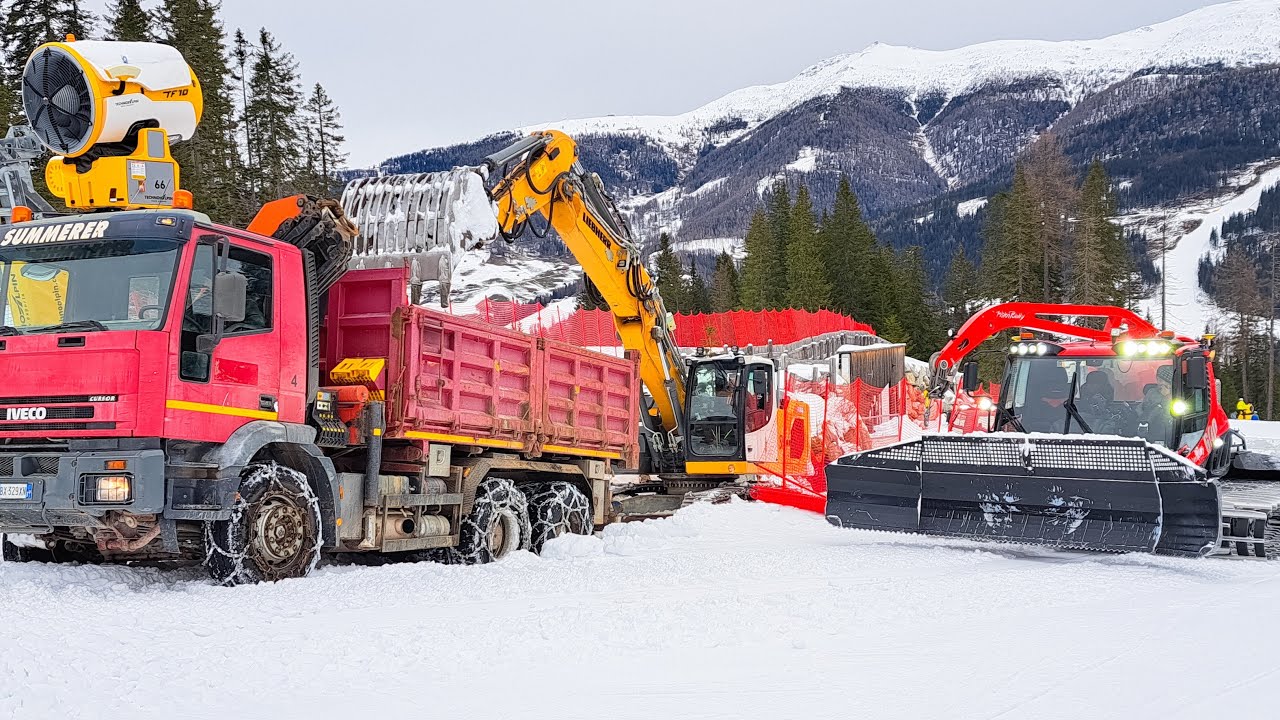 ESCAVATORE SPINGE CAMION SU PISTA DA SCI