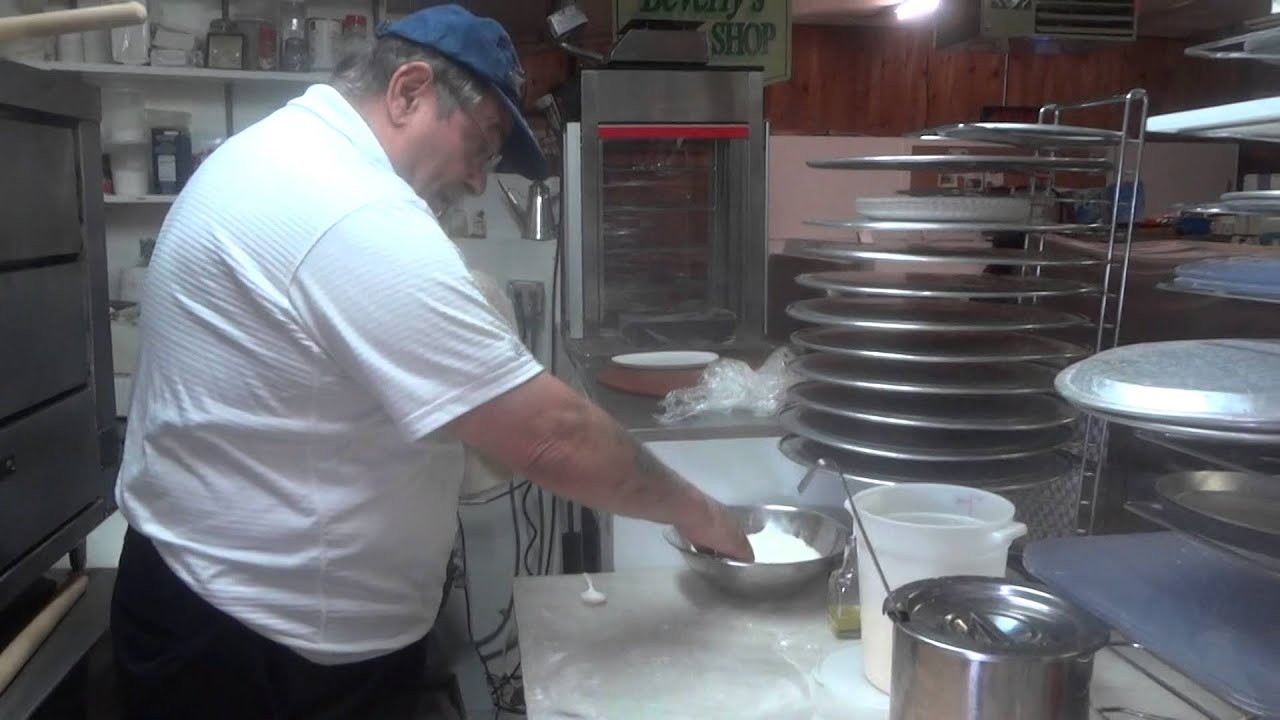 Frank Giaquinto opens up a NY style dough ball with flour