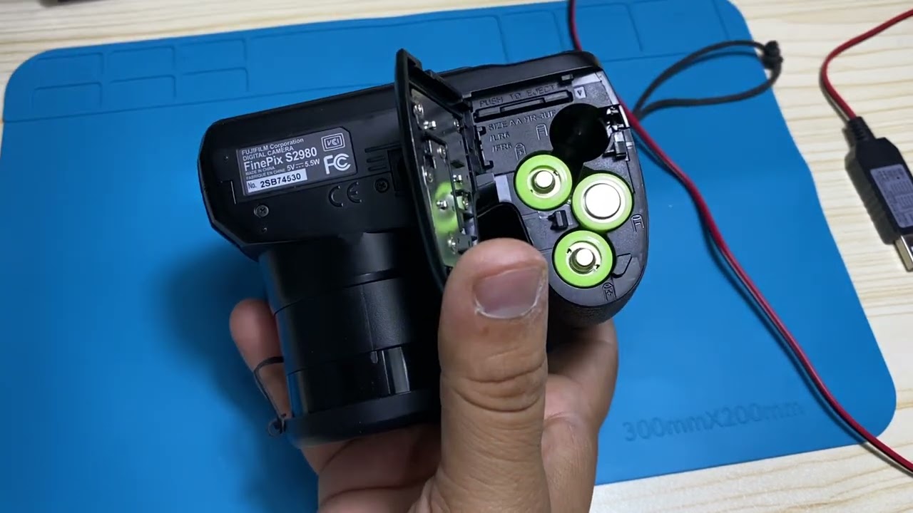cámara FUJIFILM FINEPIX S 2980 Instalación de pilas AA a USB 6V.