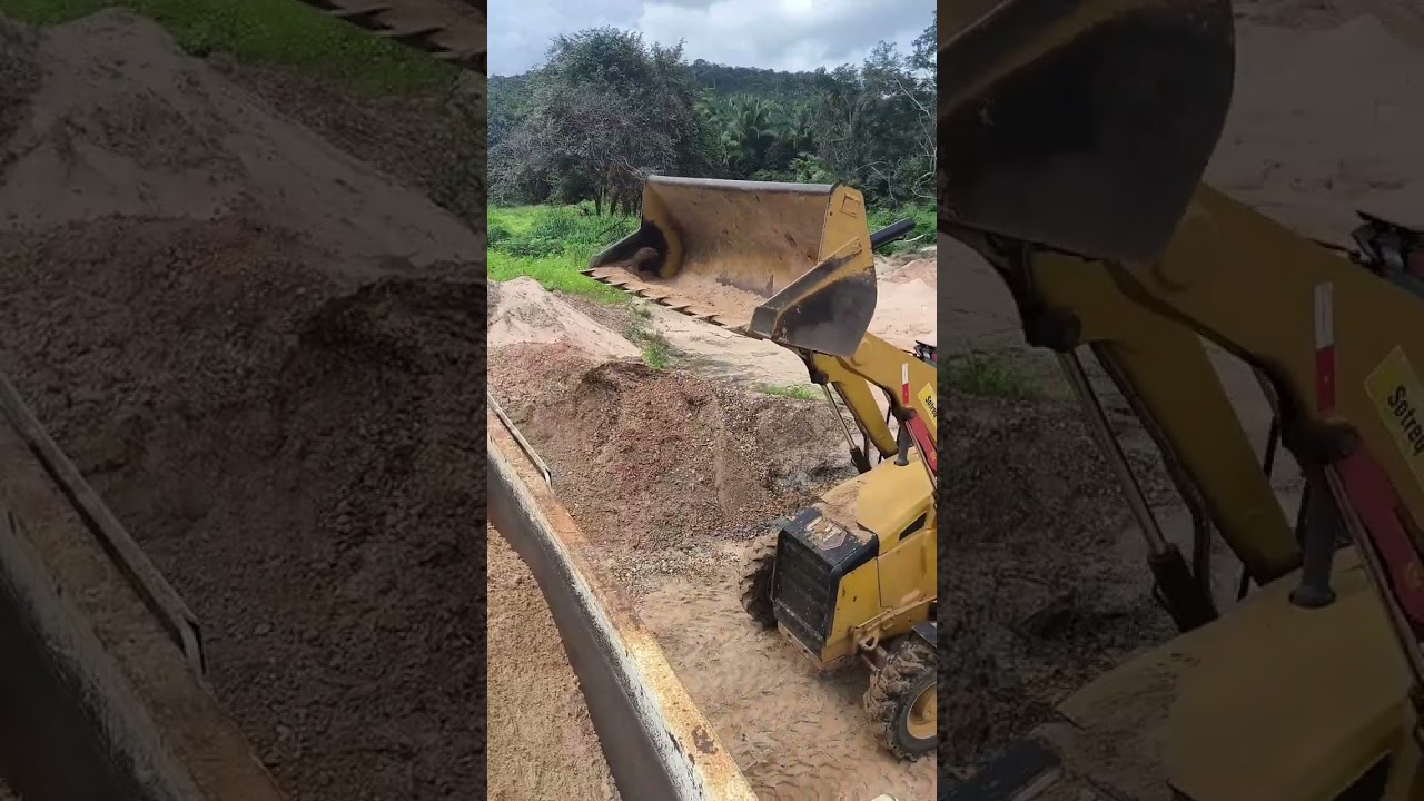 Retroescavadeira Caterpillar na jazida. Carregamento de Caçamba.