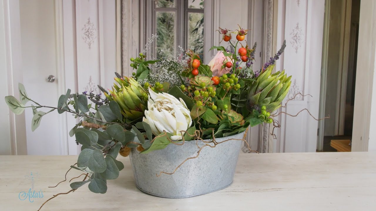 Rustic wedding table flowers of mixed proteas, lavender, berries & foliage