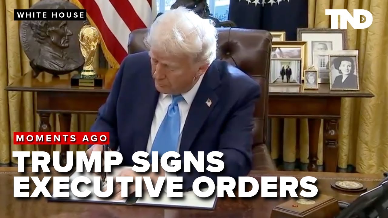President Donald Trump signs executive orders with gaggle of reporters in Oval Office