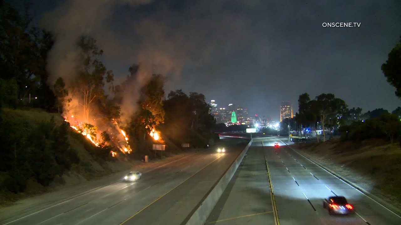 CHP Pursuit Passes By During Brush Fire On The Freeway In Boyle Heights