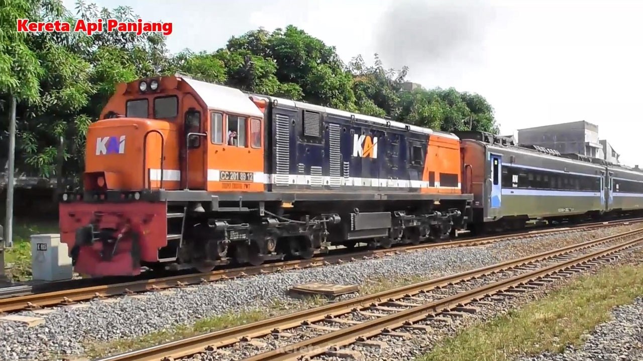 Kereta Api Panjang Lokomotif CC206 CC201 Melaju Cepat Melewati Perlintasan dan Jembatan