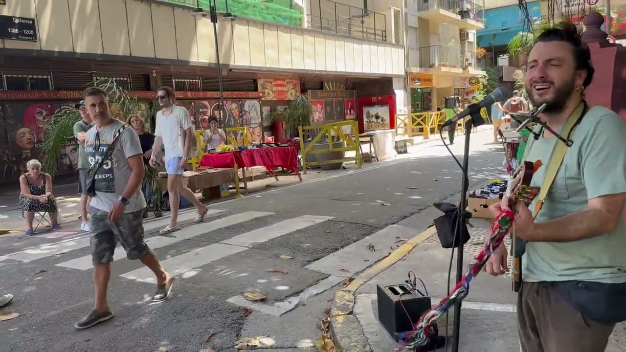 Artista di strada italiano canta in un mercato a Buenos Aires e viene circondato dai passanti