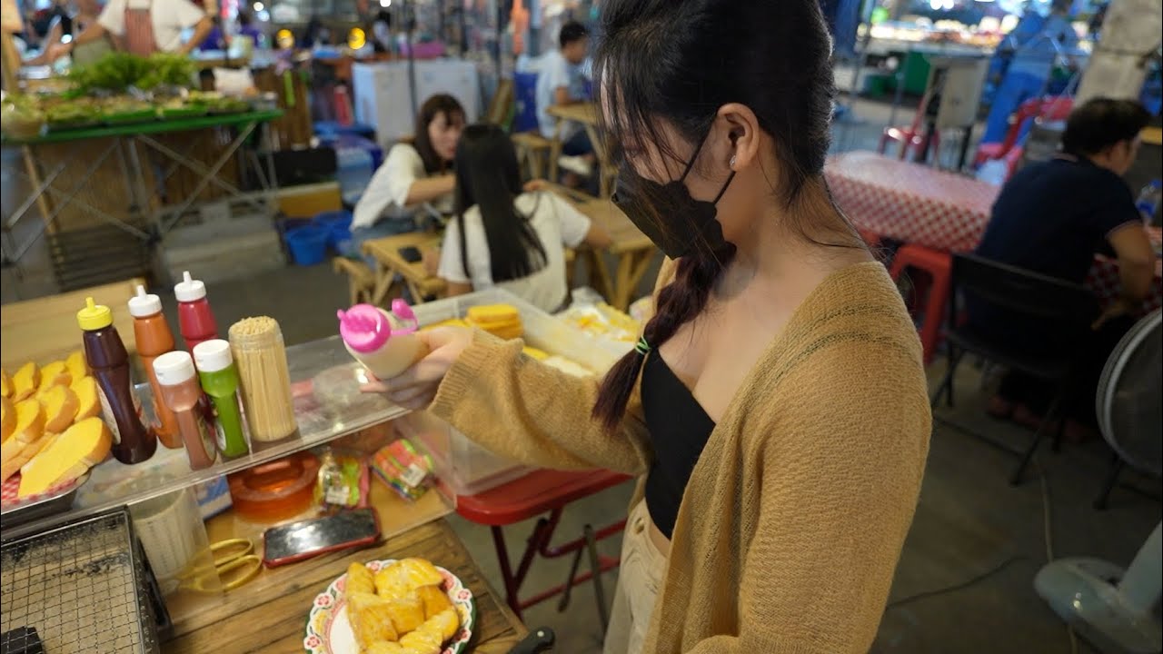 Cooking Grilled Toast and Marshmallows by pretty and shy girl at Thai night market - Thai steet food