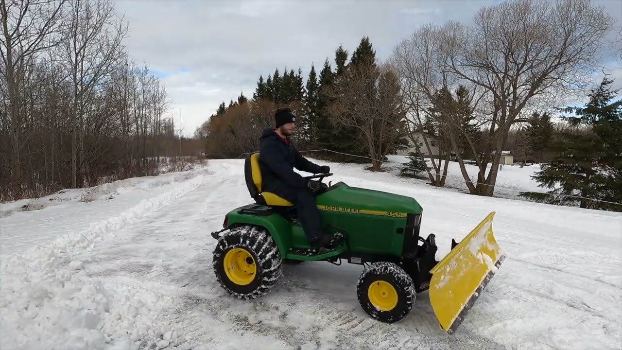 John Deere 455 plowing snow in the daytime