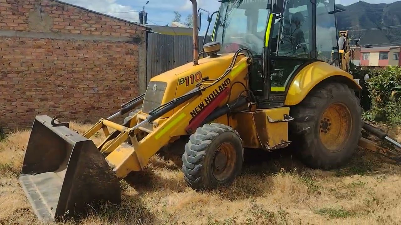 RETROEXCAVADORA EN TRABAJO DE DESCAPOTE O LIMPIEZA DE UN TERRENO