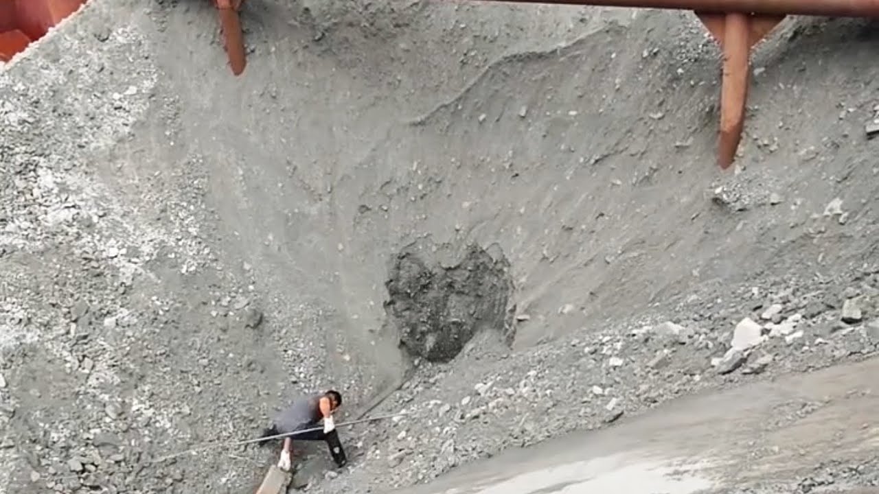 Barge unloads 2890 tons of ore - Workers unload by hand without tools.