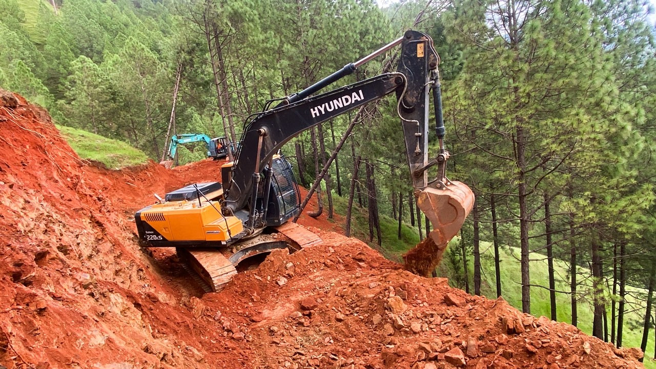 Hyundai Excavator Carving a Road Through Untouched Mountain Jungle