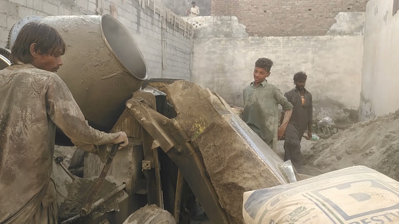 team working in pakistan working with cement mixer machine during construction