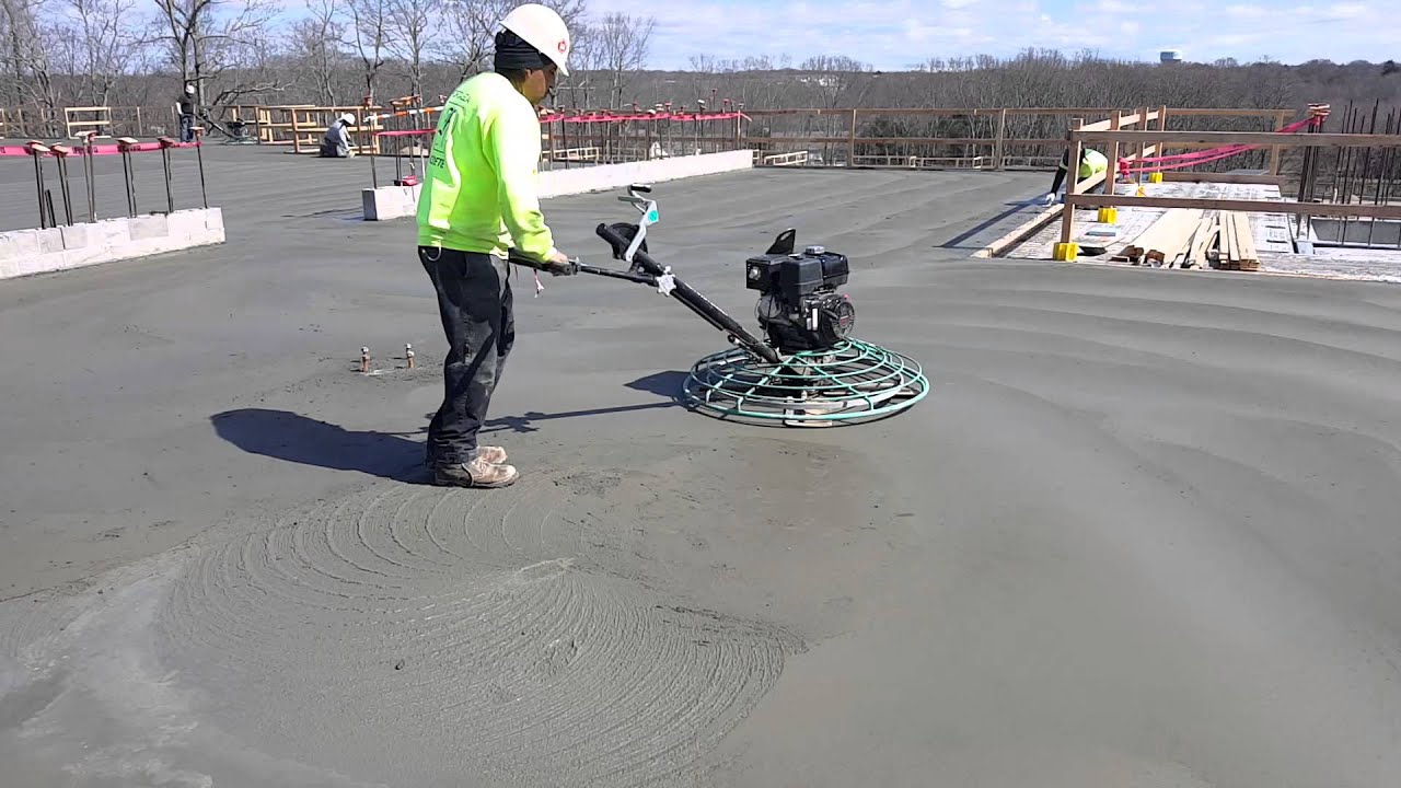 Finishing a concrete floor using a 4 foot walk-behind power trowel.