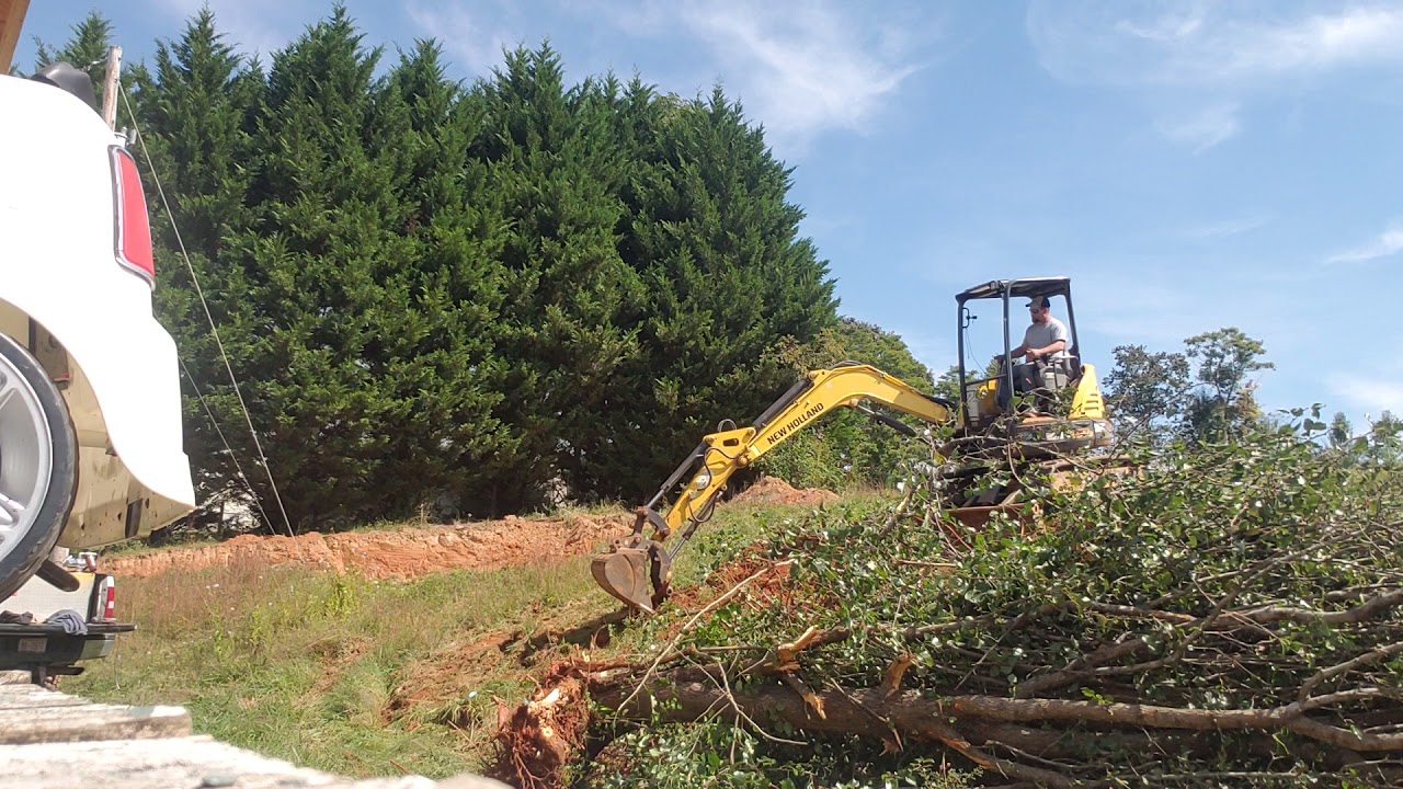 e37c newholand mini excavator takes making  Is short work of a tree