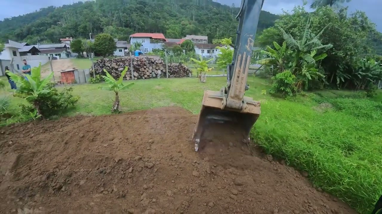 escavadeira espalhando barro