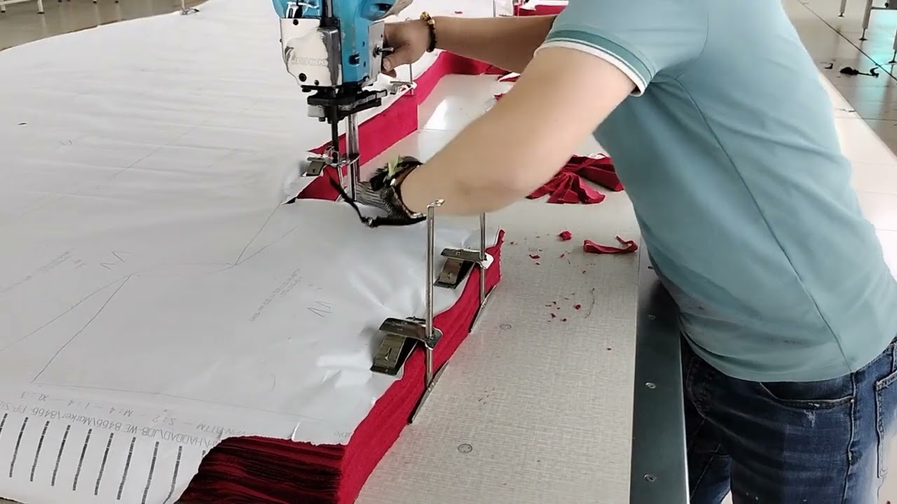 Khi quản đốc nhà cắt thể hiện cắt vải bằng máy cắt cầm tay