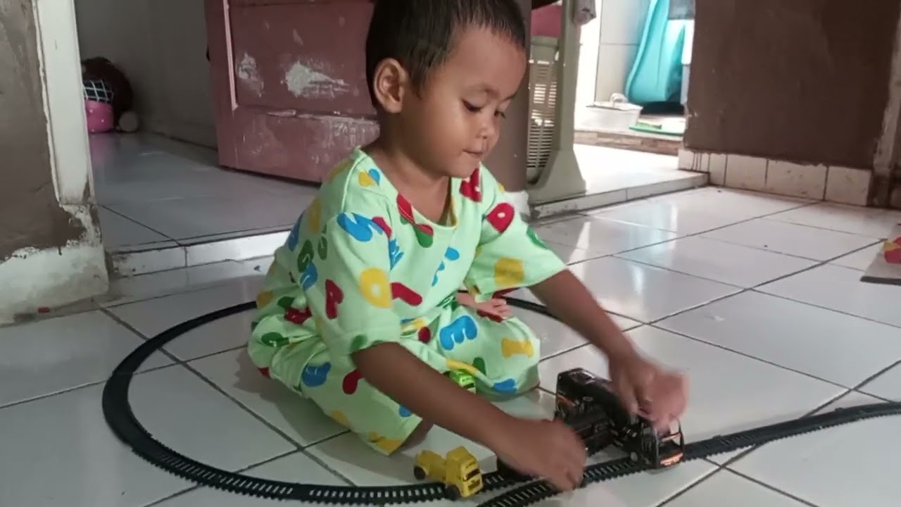 Bermain mainan kereta api bersama aa dan dede