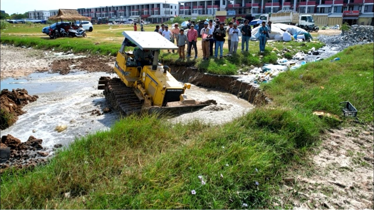 Great skill operator bulldozer pushing soil build new with dump truck unloading soil landfilling up