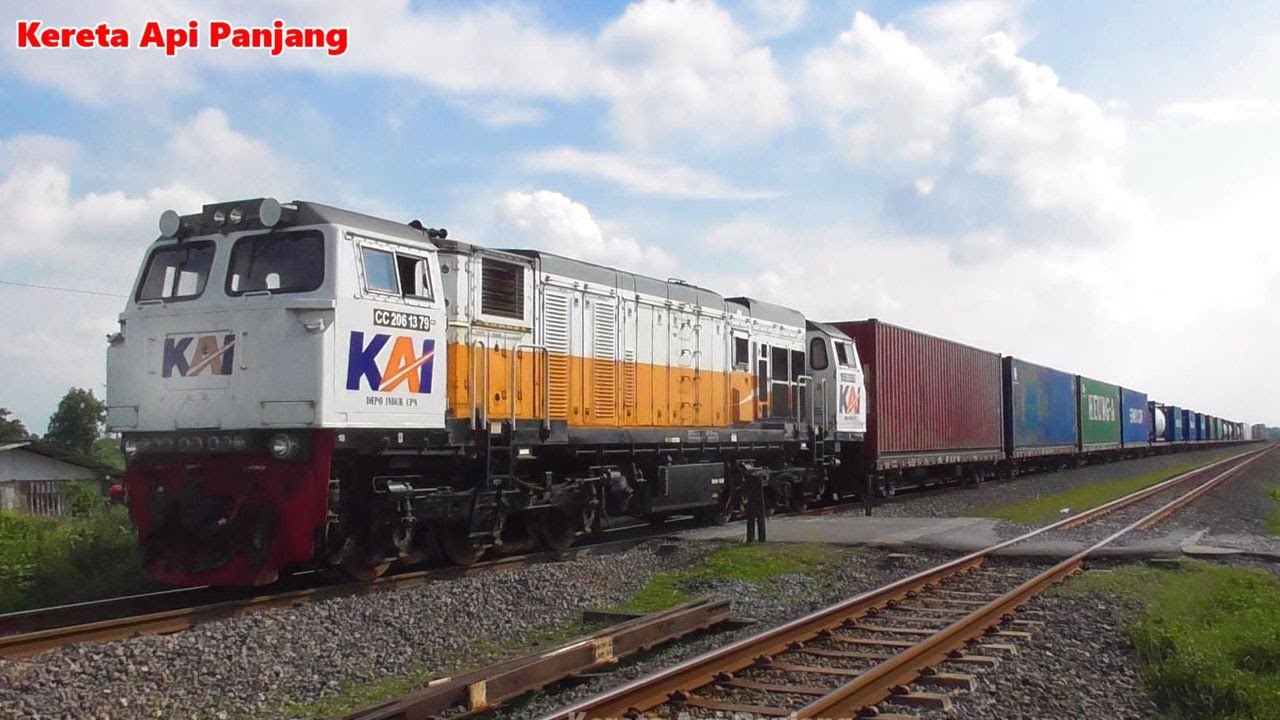 Lokomotif CC206 Narik Gerbong Logistic Menyala Kereta Api Panjang CC201 Melewati Palang Pintu