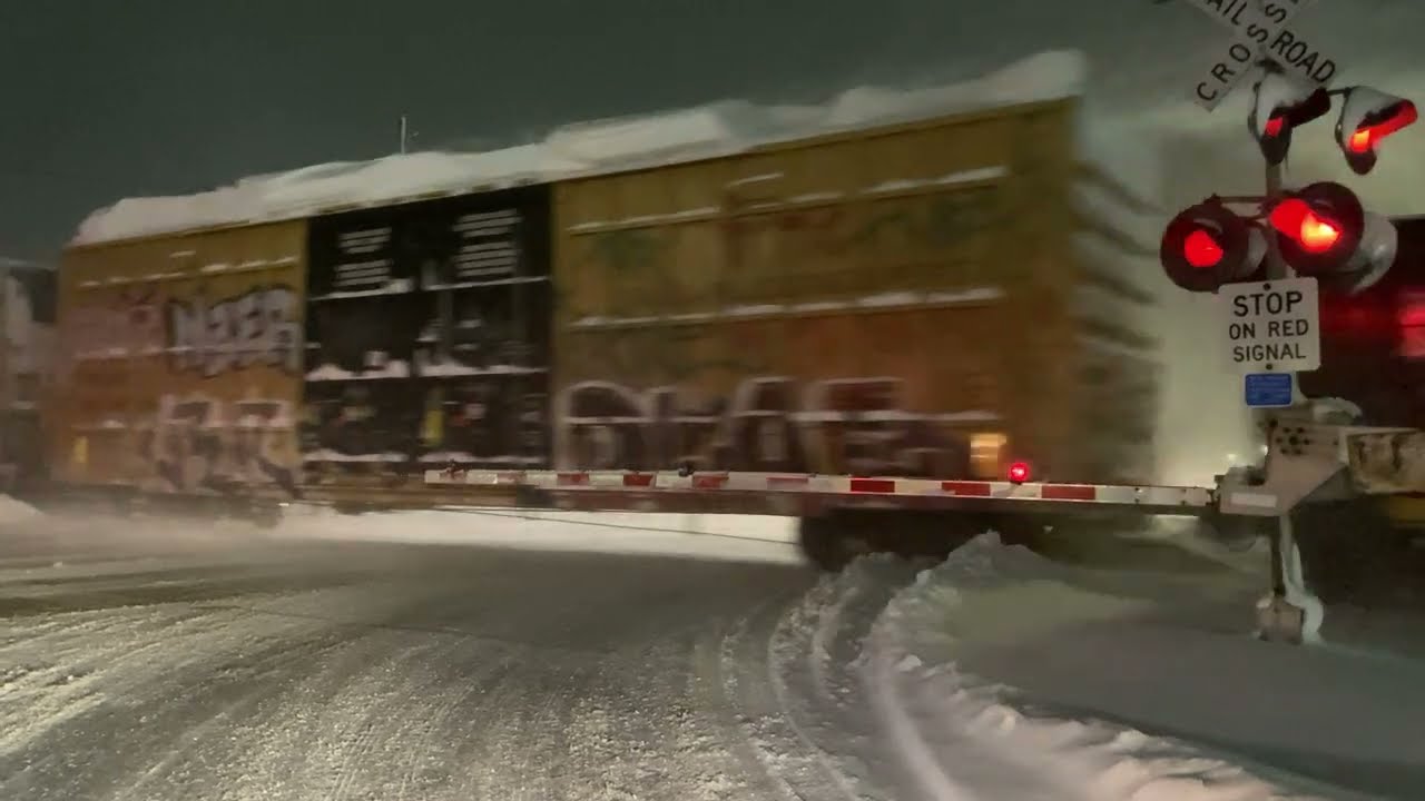 Train Crosses Snowy Street During Blizzard