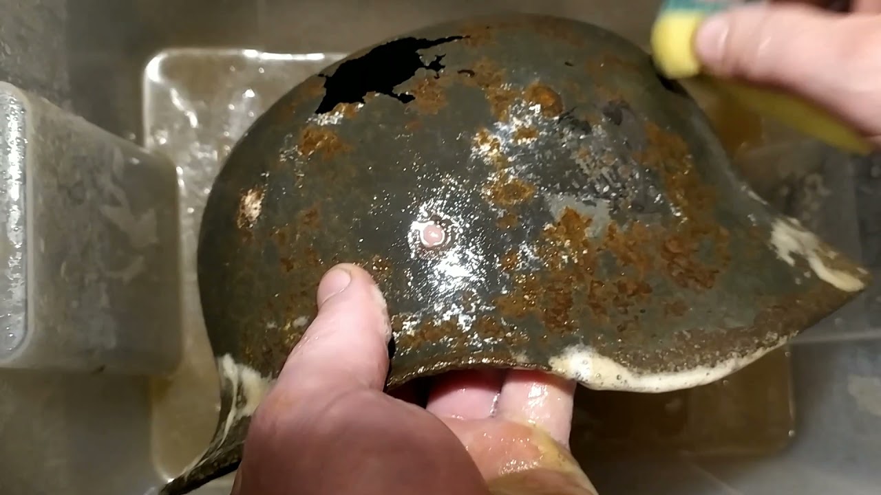 cleaning a German helmet in oxalic acid. sticker curve.