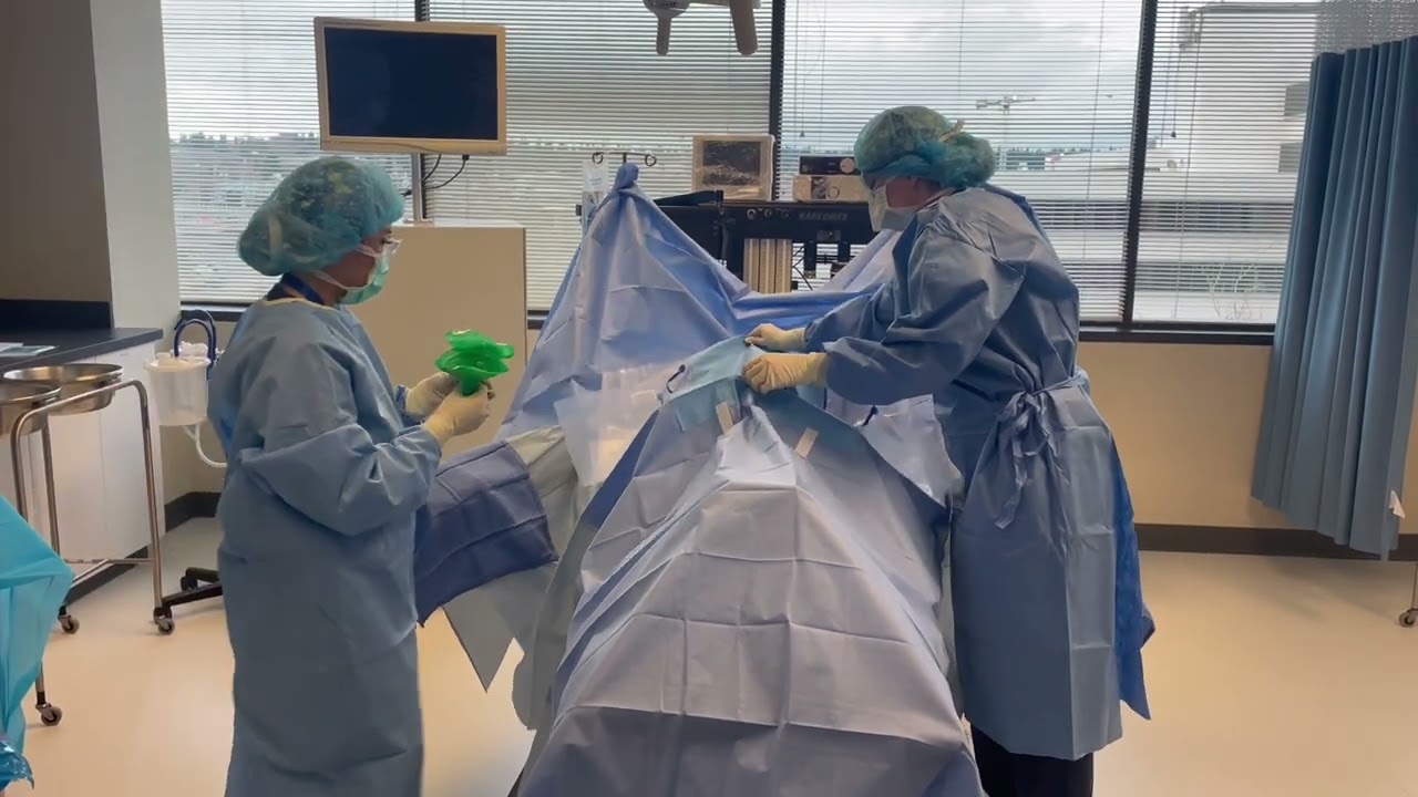 PIMA Seattle students KayLee and Elizabeth are aseptically draping the field and removing the drapes