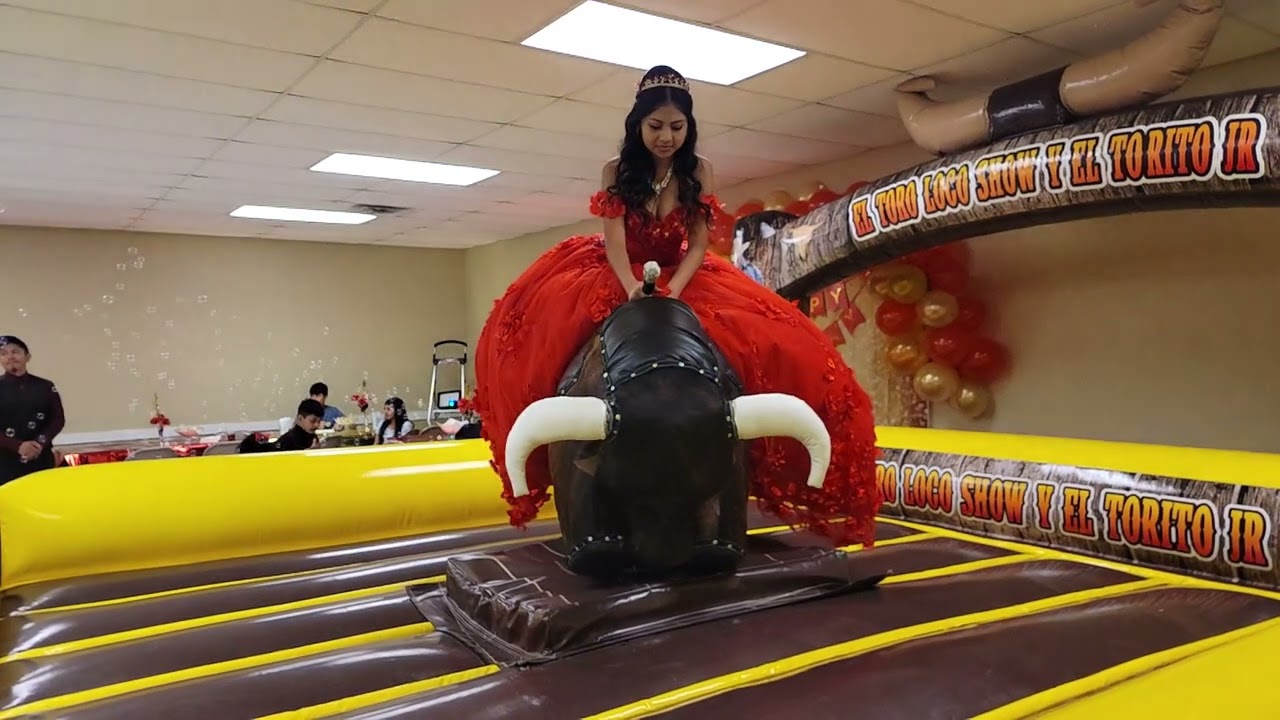 quinceañera montando el toro mecánico