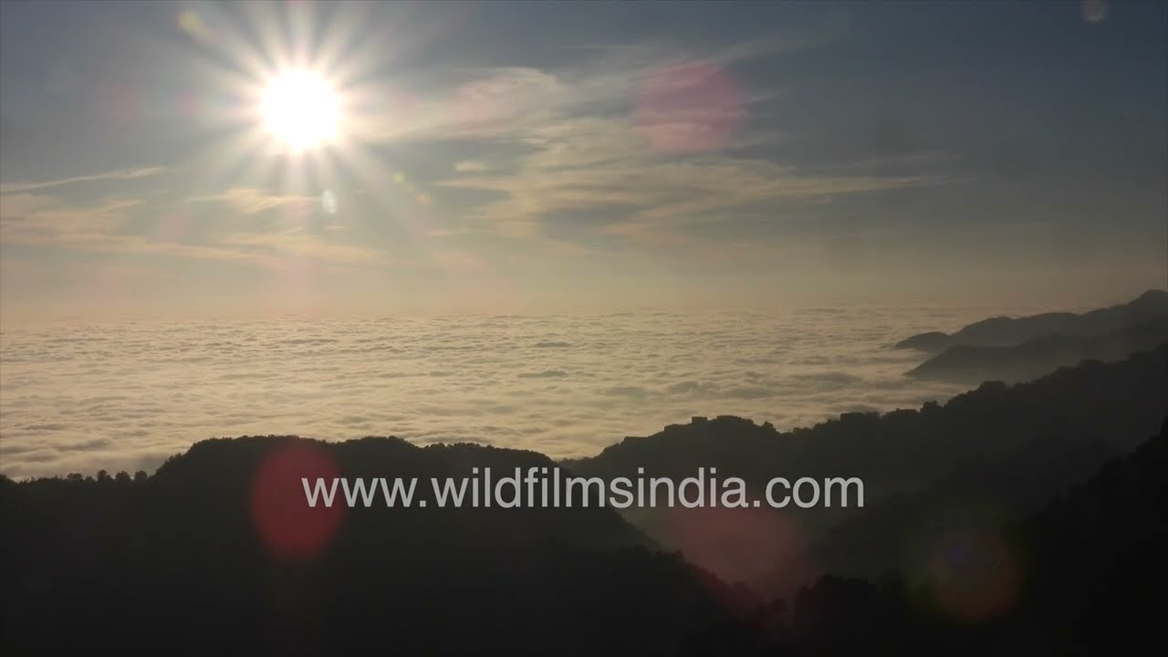 Breathtaking view of Jabberkhet, Mussoorie layered Himalayan Mountains under dynamic Clouds and Sun