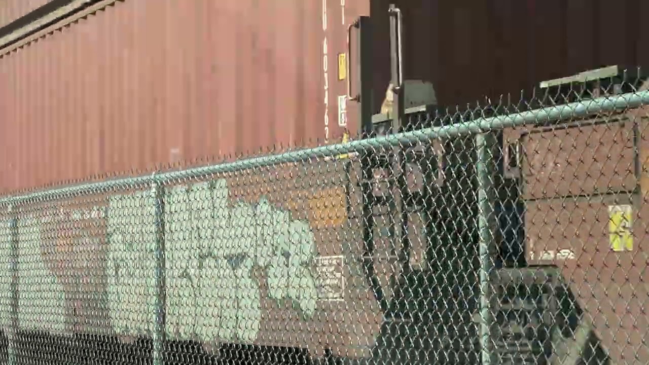 Driving in the opposite direction as fast intermodal railroad trains zooms by super close to road