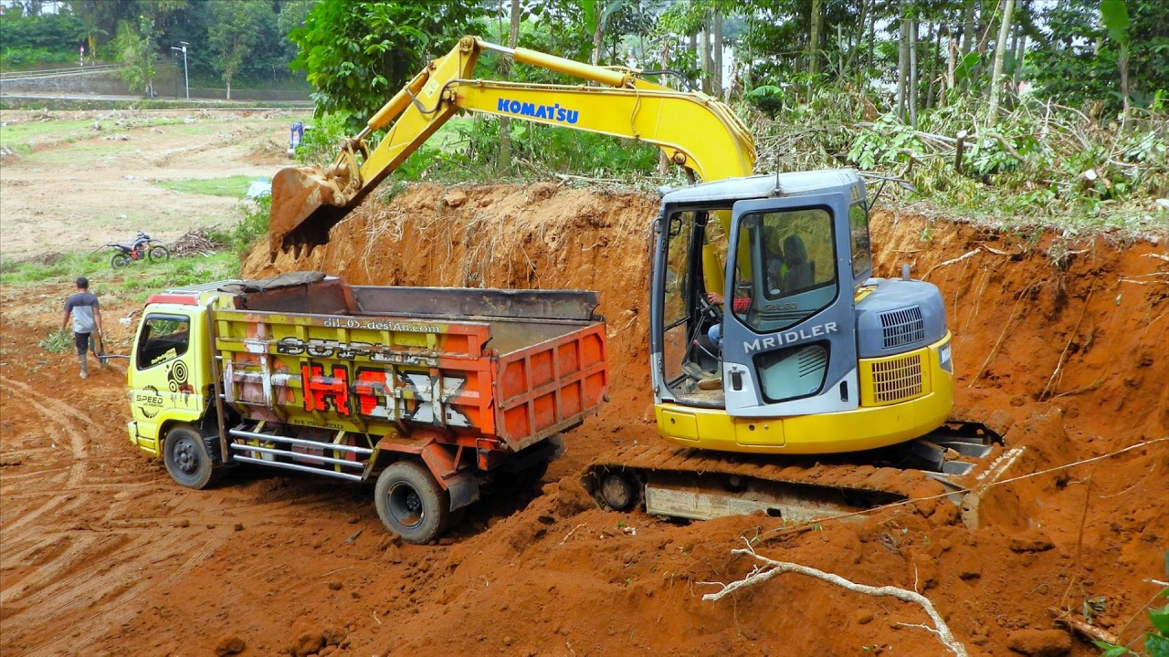 Loading Soil Into Trucks With a Mini Excavator