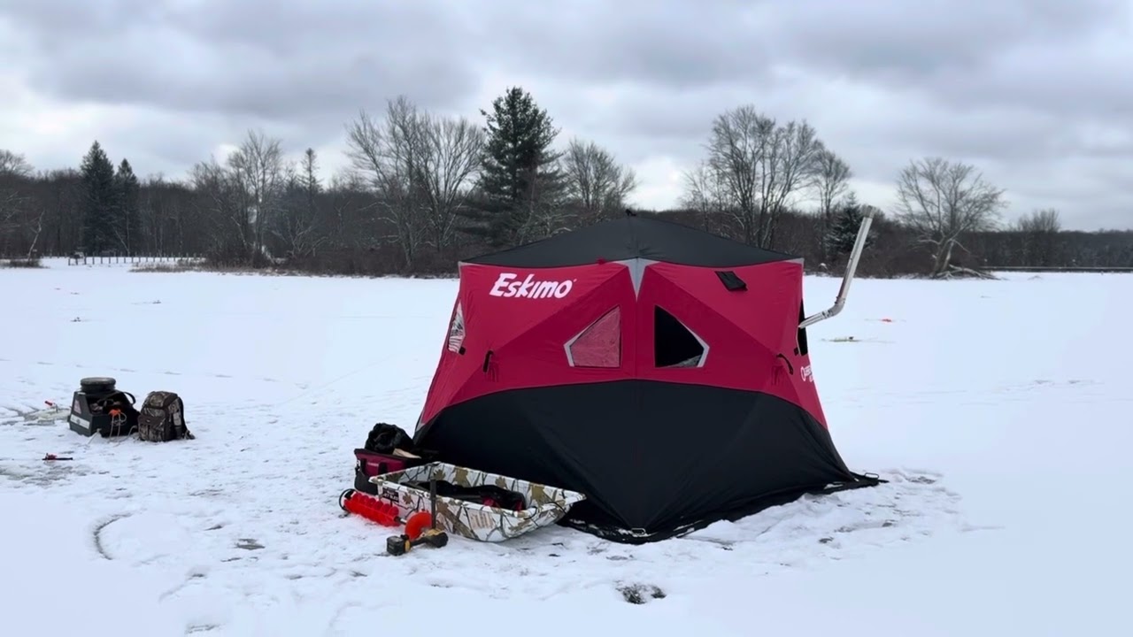Camping winter,Ice fishing. Eskimo tent wood stove cooking