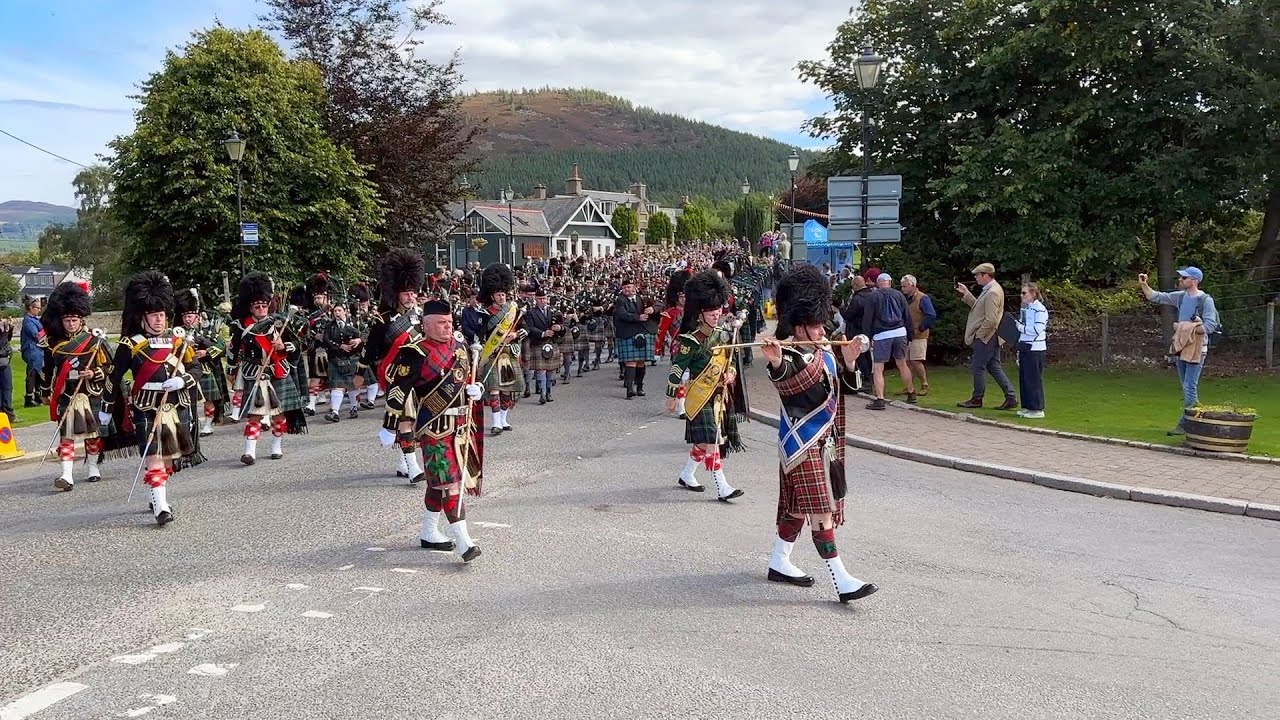 Massed Pipes and Drums marching to the 2023 Braemar Gathering Highland Games in Scotland