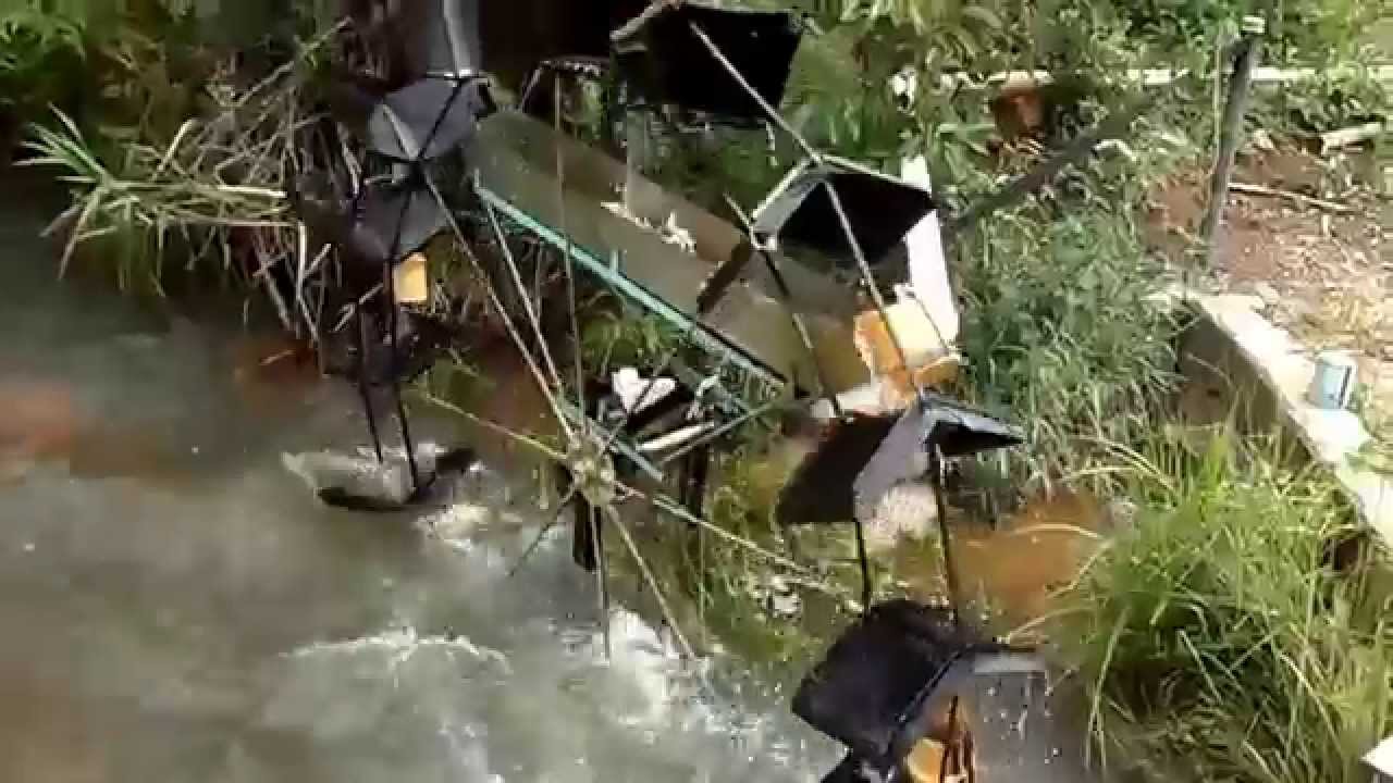 Roda d'agua movida pela correnteza do rio funcionando com rio cheio. Eleva a &aacute;gua