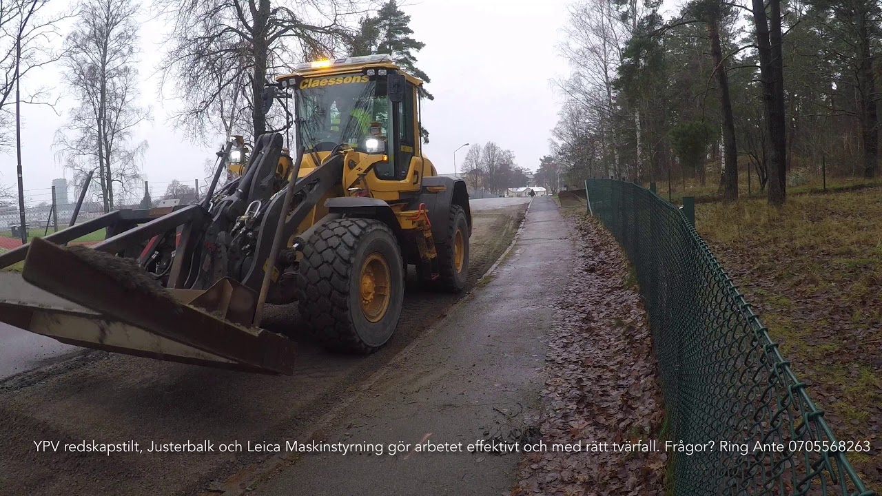 Volvo L90H ripping asphalt and working with grading beam.
