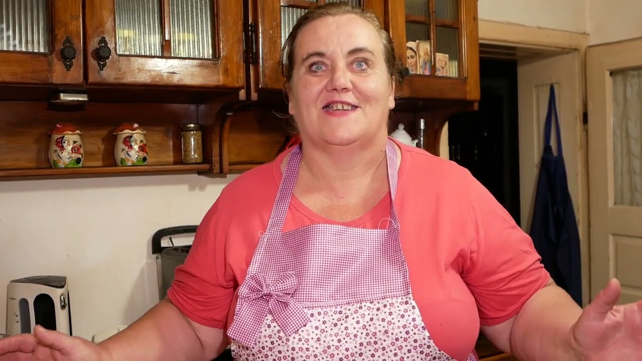Papanași prăjiţi cu brânza de vaci serviți cu smântână și dulceață de afine